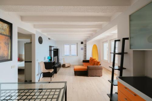 a living room with an orange couch and chairs at Beach Appartament in Marina di Montemarciano