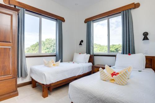 two beds in a room with two windows at Seiri del Mar in Hopkins