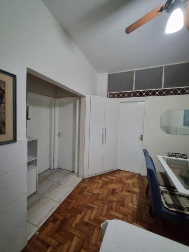 a living room with white cabinets and a wooden floor at Comodidade e Segurança no Centro in Belo Horizonte