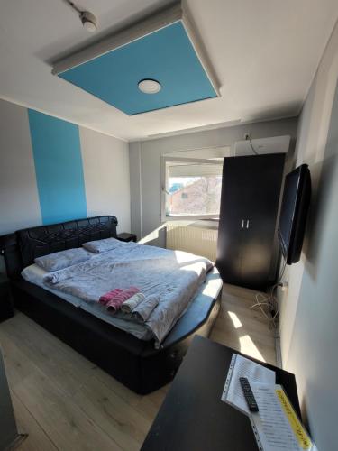 a bedroom with a bed and a desk and a window at Kristal 2 in Zrenjanin