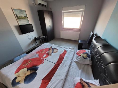 a bedroom with a bed with a comforter on it at Kristal 2 in Zrenjanin