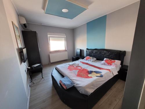 a bedroom with a large bed with a black headboard at Kristal 2 in Zrenjanin