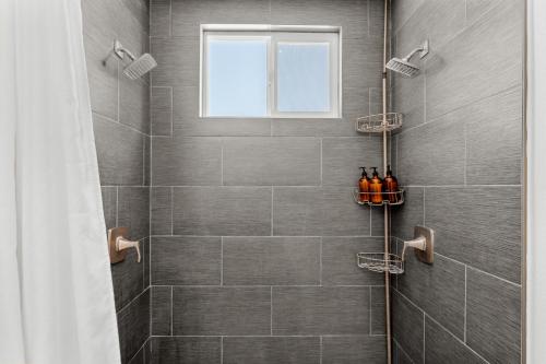 een badkamer met een douche met grijze tegels bij Family Retreat Hot Tub & Private King Casita in Morongo Valley