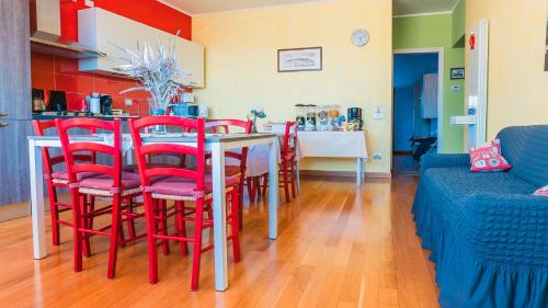 a room with a table with red chairs and a kitchen at Bed and Breakfast Torre Polidori in Orvieto