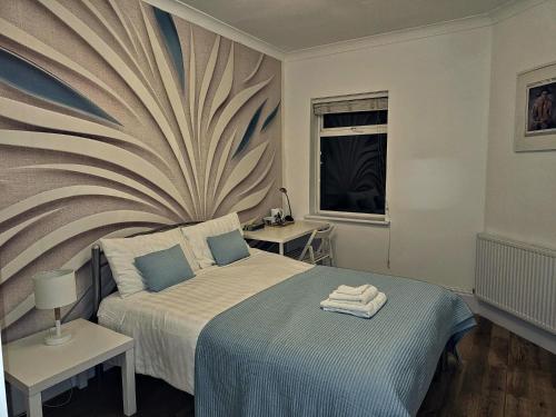 een slaapkamer met een bed met een schilderij aan de muur bij Rosie Blue in Londen