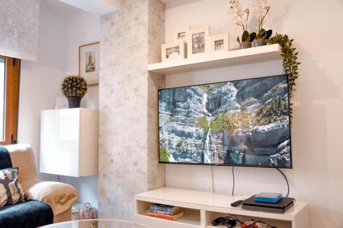 ein Wohnzimmer mit einem Flachbild-TV an der Wand in der Unterkunft ConIDE APARTAMENTO 3 DORMITORIOS in Oviedo