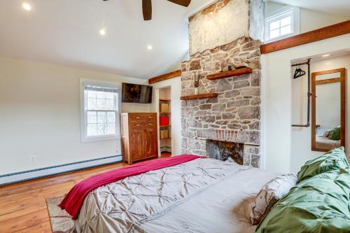 1 dormitorio con chimenea de piedra y 1 cama en Historic Yardley Retreat - 1 Block to the River!, en Yardley