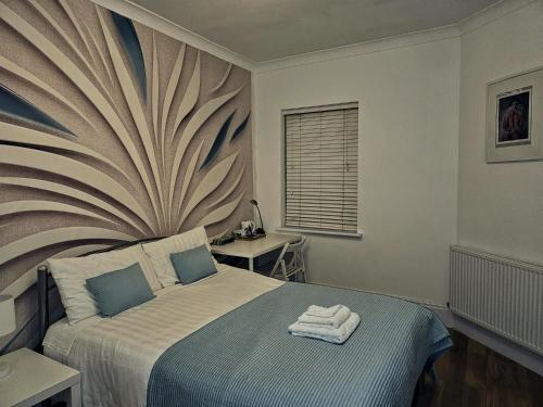een slaapkamer met een bed met handdoeken erop bij Rosie Blue in Londen
