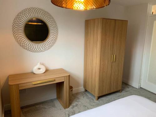 a bedroom with a wooden cabinet and a mirror at Waterfront view apartment in Lincolnshire