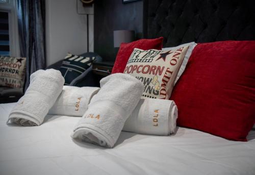 eine Gruppe gerollter Handtücher auf einem Bett mit Kissen in der Unterkunft Victoria Loft in Bowness-on-Windermere