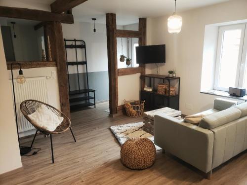 - un salon avec un canapé et une chaise dans l'établissement Emile&Jeanne - Centre - 2 chambres - Wifi, Netflix, à Wissembourg