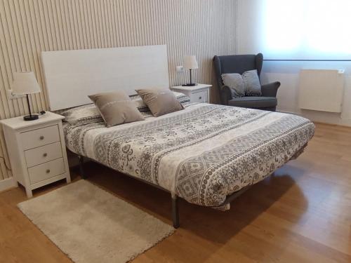 1 dormitorio con 1 cama grande y 1 silla en Apartamento Peace Home Astillero en El Astillero