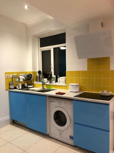 a kitchen with a sink and a washing machine at Rosie Blue in London