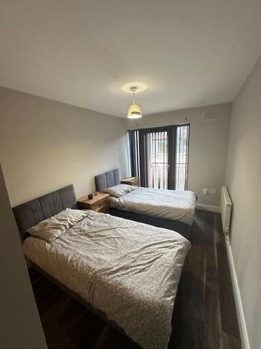a bedroom with two beds and a window at Iacomm Newbridge 2 bed apt in Newbridge