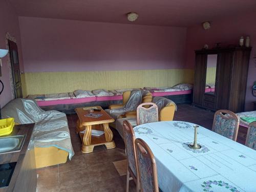 a living room with tables and chairs and a couch at Penzion U strhaného klempíře in Ropice