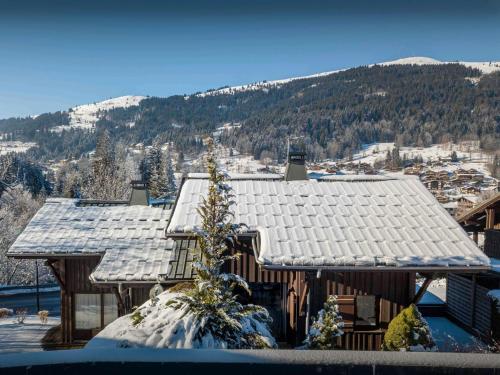une cabane en rondins avec de la neige sur le toit dans l'établissement Chalet Kouzya - OVO Network, aux Gets