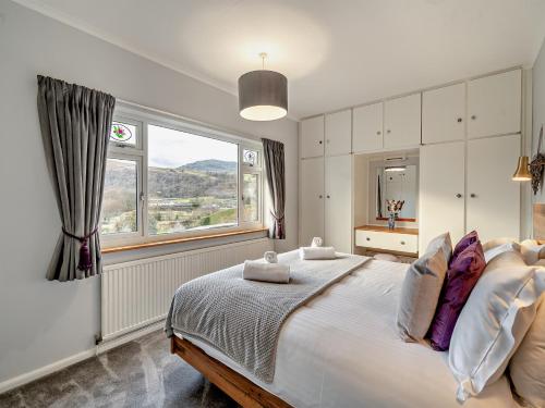 a bedroom with a large bed with a large window at 3 Bed in Coniston 93329 in Torver