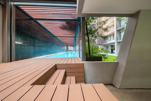 a wooden deck with a swimming pool in a building at Lumina at Taman Condesa in Mexico City