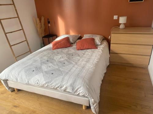 une chambre avec un lit avec deux oreillers et une échelle dans l'établissement Studio cosy, centre historique, à Malestroit