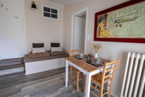 a dining room with a table and a bed at Les granges du chiron in La Garnache