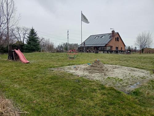 a pile of sand in a field with a house at Penzion U strhaného klempíře in Ropice