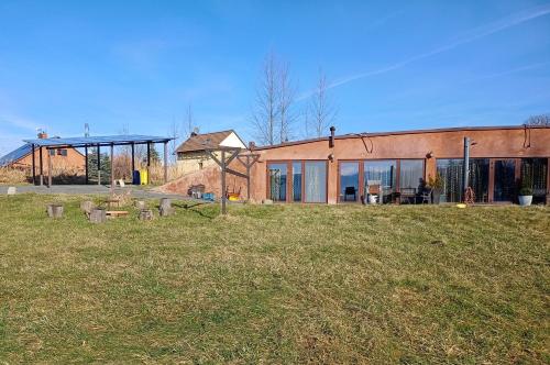 a building with a grass field in front of it at Penzion U strhaného klempíře in Ropice