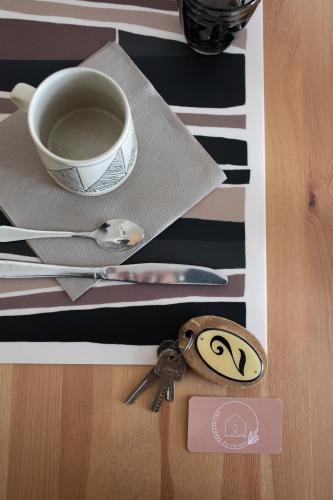 a table with a cup of coffee and a keychain at Les granges du chiron in La Garnache