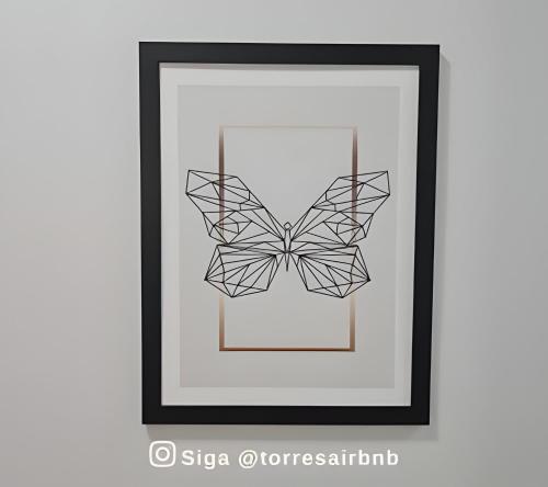 a framed picture of a origami butterfly at Apto 02 quartos | Ar | 500mts do mar | Aceita Pet in Torres