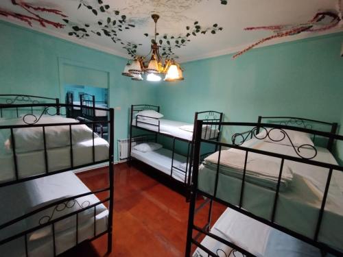 a room with four bunk beds and a ceiling at Sweet Home Hostel in Baku