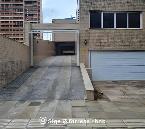 a building with a parking lot with a garage at Apto 02 quartos | Ar | 500mts do mar | Aceita Pet in Torres