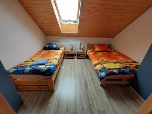 2 łóżka w małym pokoju z oknem w obiekcie Agroturystyka Leśna Malinka 