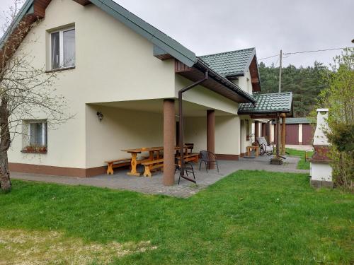 a patio with a picnic table and a house at Agroturystyka Leśna Malinka in Celejów