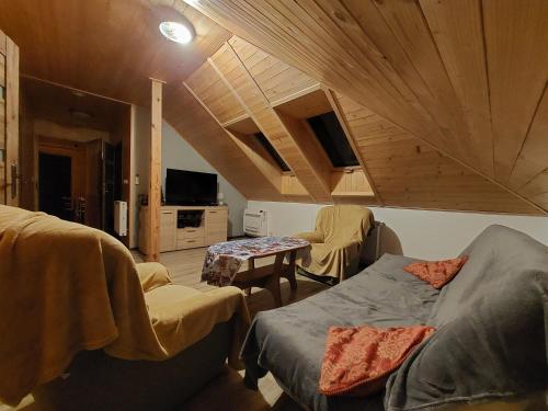 a room with two beds and a table in a room at Agroturystyka Leśna Malinka in Celejów