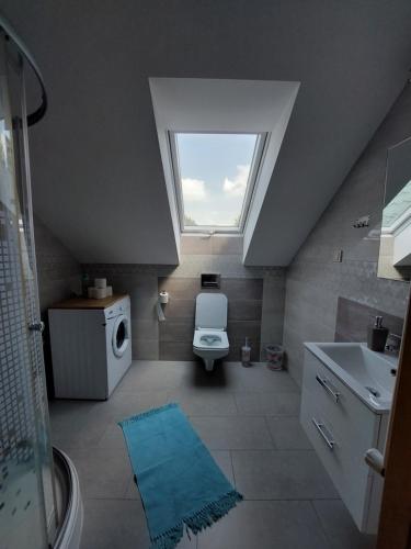 łazienka z toaletą, umywalką i oknem w obiekcie Agroturystyka Leśna Malinka 