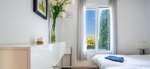 1 dormitorio con 1 cama y un jarrón con flores en La Torre Golf Resort en Roldán