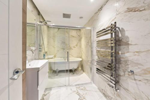 bagno con vasca, lavandino e doccia di Richmond Riverside Villa a Richmond