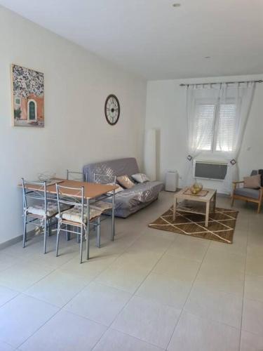 uma sala de estar com uma mesa e um sofá em 2 pièces rez-de-chaussée Mandelieu em Mandelieu-la-Napoule