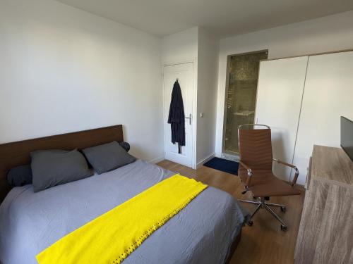 ein Schlafzimmer mit einem Bett, einem Stuhl und einem Fenster in der Unterkunft Appartement 2 pièces proche de Paris in Charenton-le-Pont
