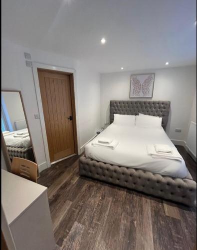 a bedroom with a large bed in the corner of the room at The Birch Lodge located in Pegsdon in Hexton