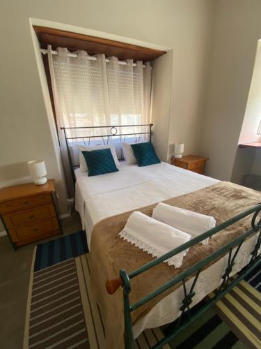 um quarto com uma cama grande e almofadas azuis em Quinta José&Maria Quartos Ferreira do Zêzere em Ferreira do Zêzere