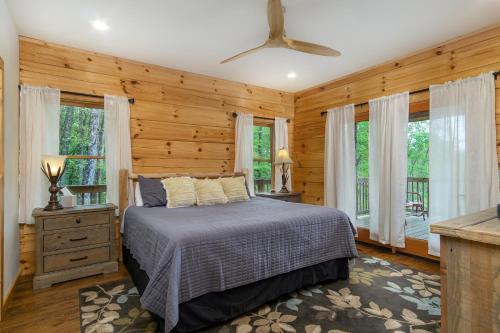 マリオンにあるMountain Crest Pet-friendly Log Cabin with Mountain Views!のベッドルーム1室(木製の壁と窓のあるベッド1台付)