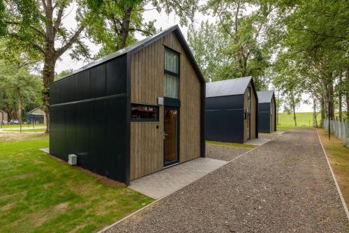 una casa con tetto nero e garage nero di Tisza-tó Glamping Abádszalók ad Abádszalók