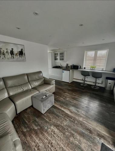 sala de estar con sofá y cocina en The Birch Lodge located in Pegsdon en Hexton