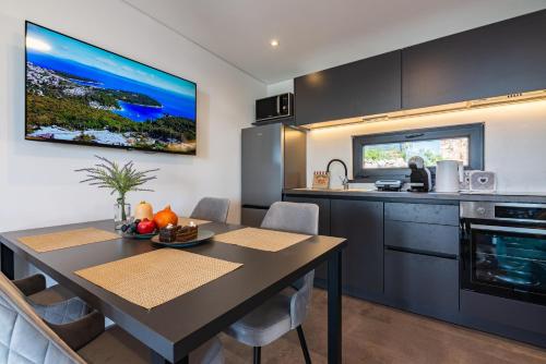 a kitchen and dining room with a table in a room at Luxury Mobile Home Kasthouse Oleander in Mali Lošinj