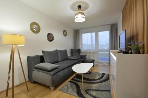 uma sala de estar com um sofá e uma televisão em Apartament Dzień Dobry 3 em Wałbrzych