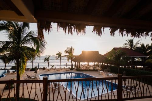 a view of a resort with a swimming pool and the ocean at Hotel Portofino in Barra de Potosi