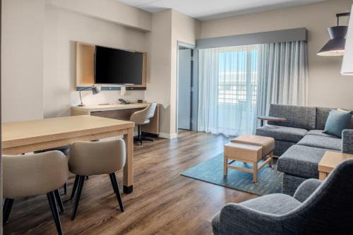 a living room with a table and a living room with a couch at Hyatt Place St Augustine Vilano Beach in Saint Augustine
