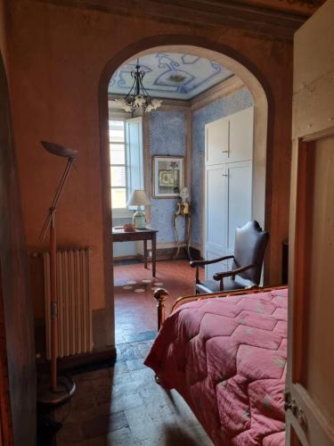 a bedroom with an archway with a bed and a desk at il Pozzo Apartment in Città di Castello