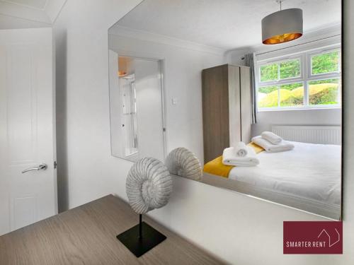 een slaapkamer met een bed en een spiegel bij Wokingham - 2 Bedroom Maisonette - With Parking in Wokingham