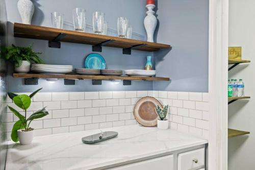 a kitchen counter with plates and glasses on shelves at Excellent Roswell Location! in Roswell